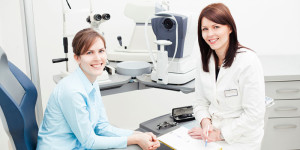 doctor and patient smiling in eye exam room
